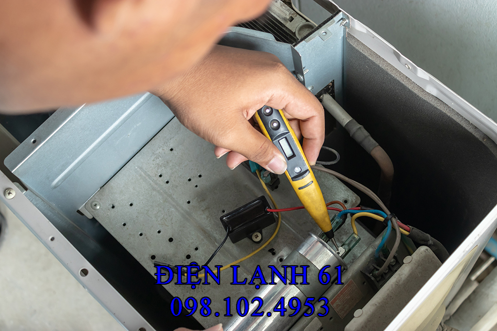 Kỹ thuật viên đo dòng điện block máy lạnh sau khi thay tụ