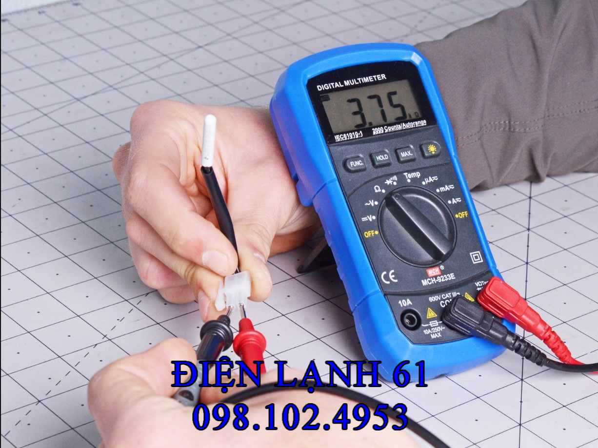 Thợ Điện Lạnh 61 đang cầm đồng hồ đo điện trở của dây cảm biến tủ lạnh