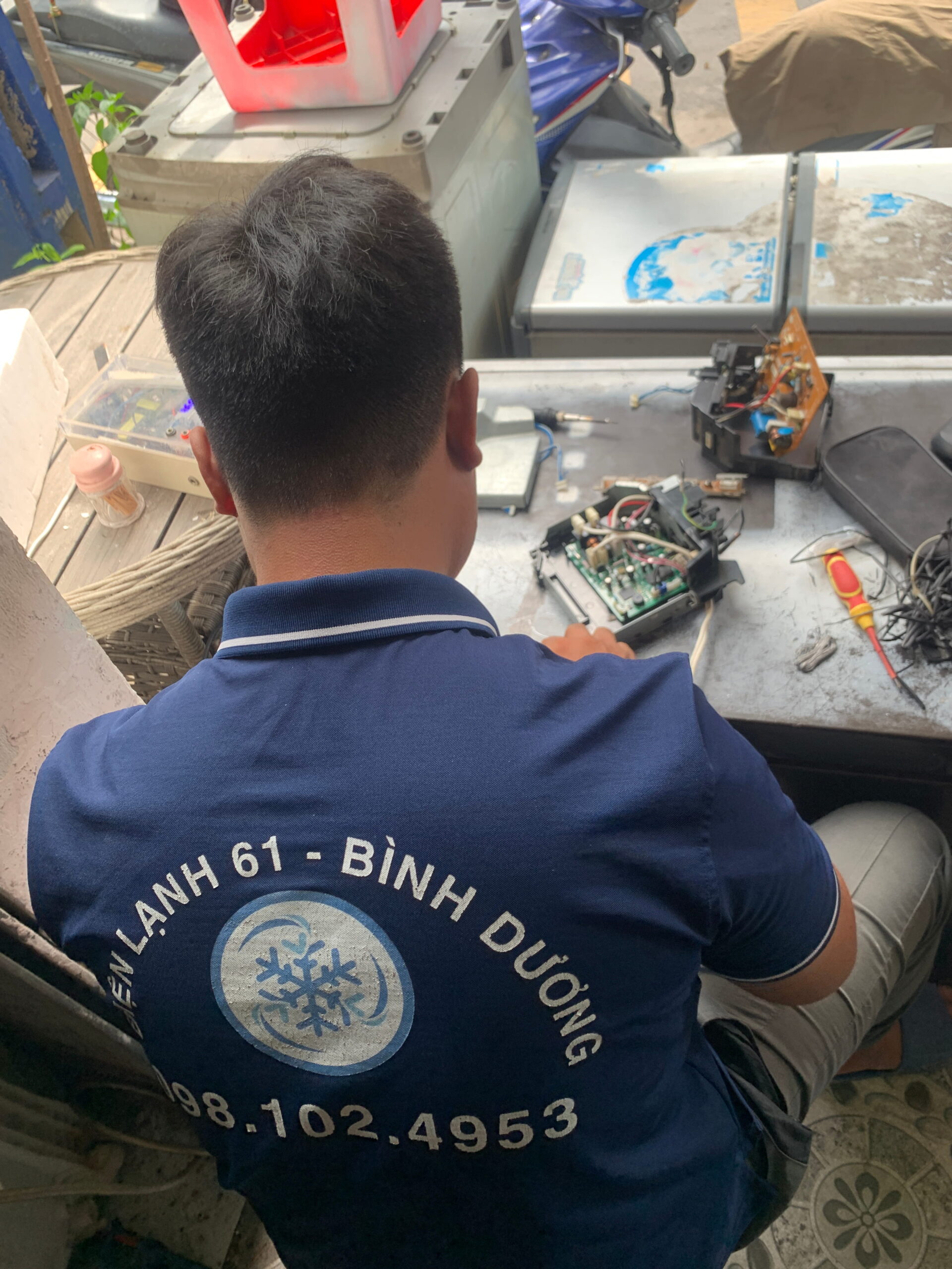 Thợ sửa bo mạch đang đo xung bằng máy hiện sóng