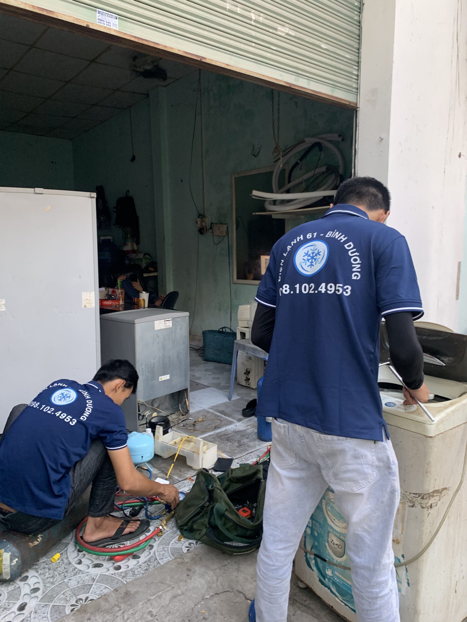 Thợ sửa máy giặt đang kiểm tra chổi than động cơ