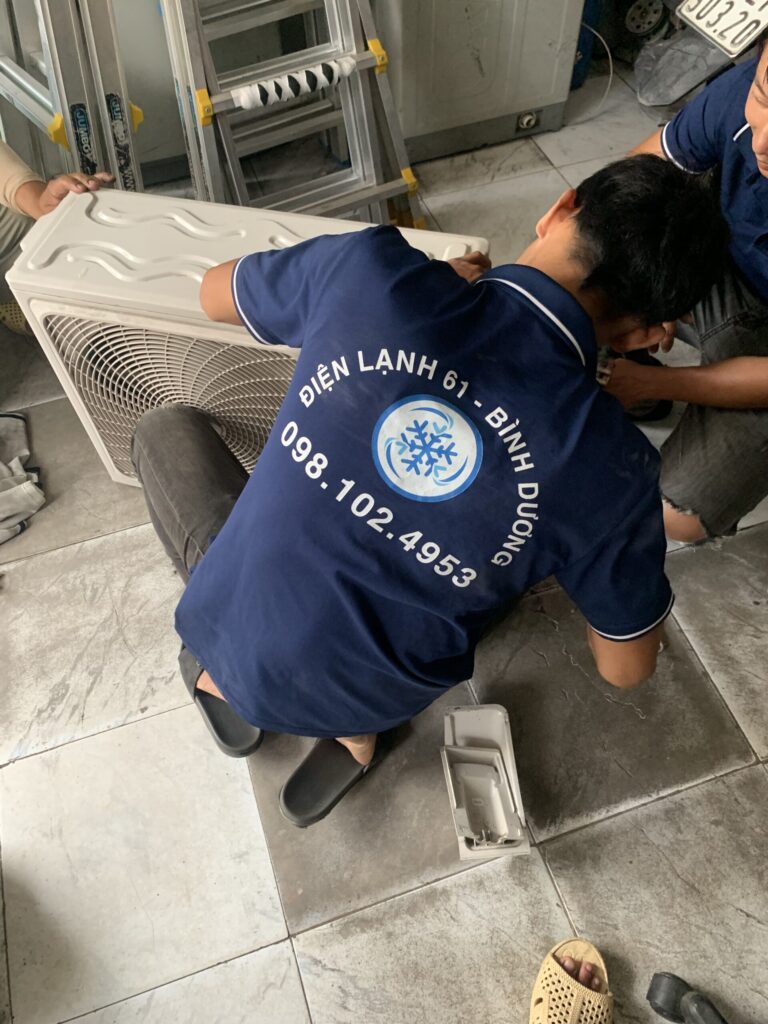 Thợ sửa máy lạnh Điện Lạnh 61 đang thay tụ cục nóng tại Dĩ An