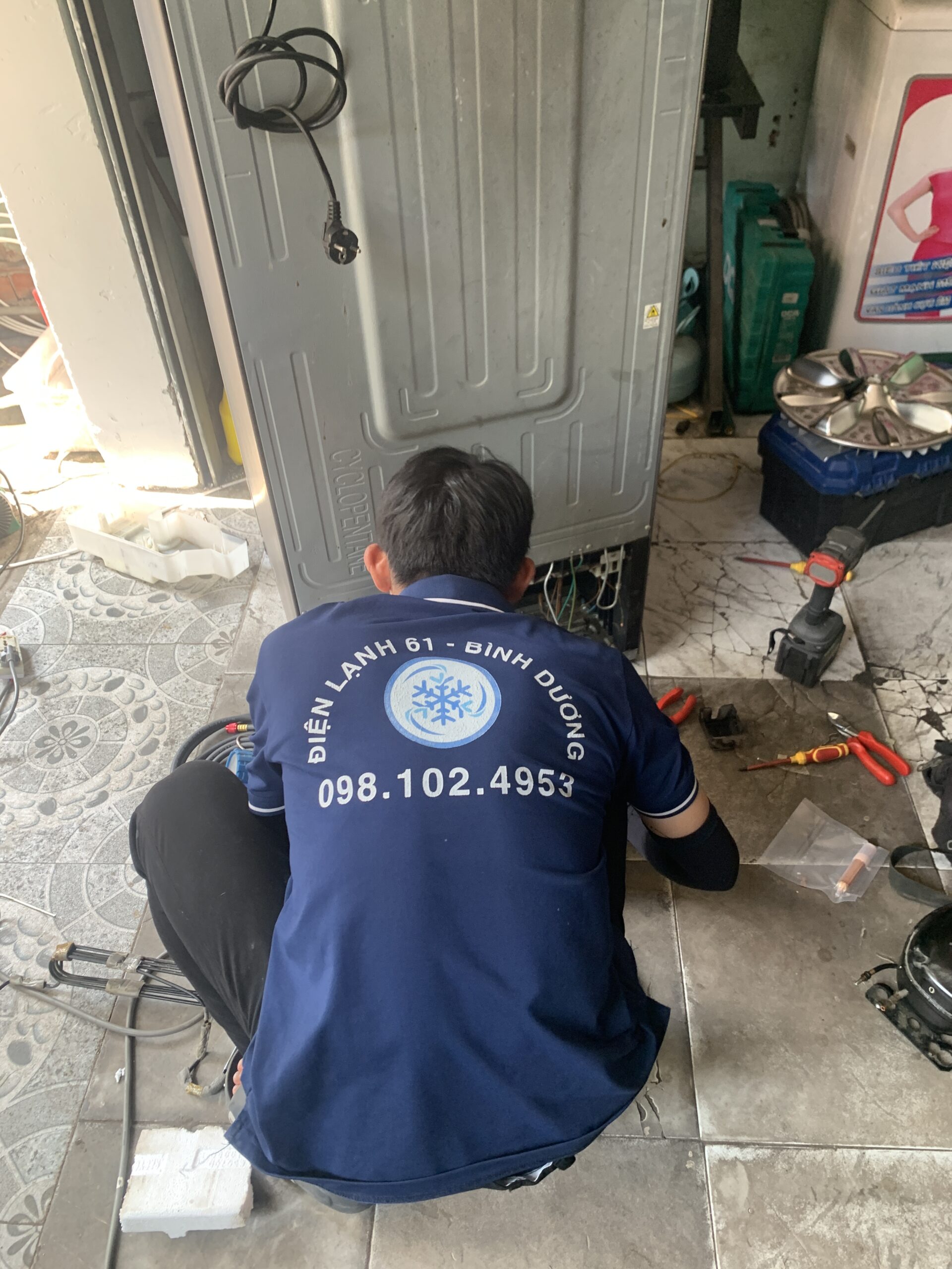 Thợ sửa tủ lạnh đang đo kiểm tra cầu chì nhiệt sò nóng