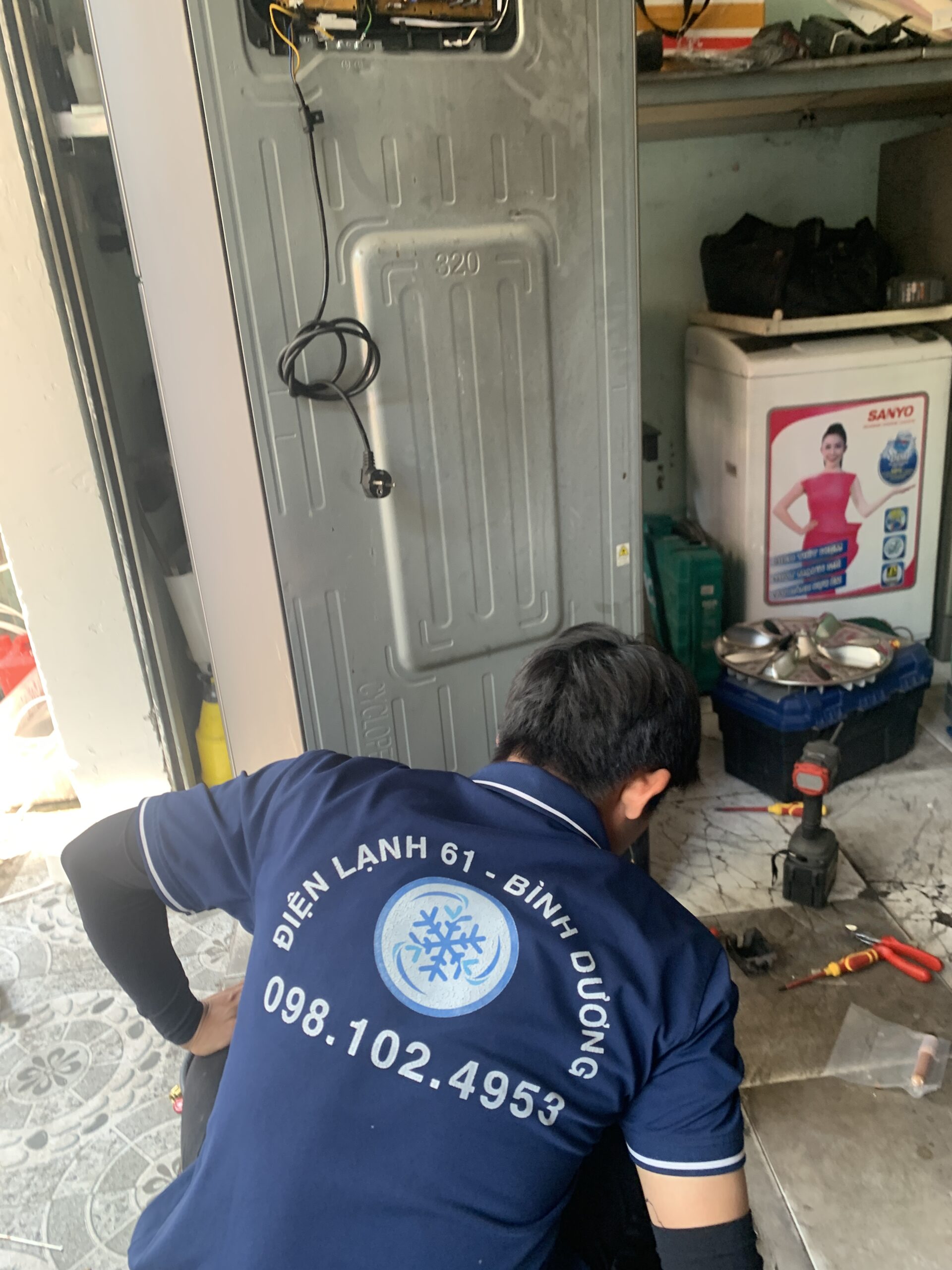 Thợ sửa tủ lạnh đang đo trị số điện trở của cảm biến