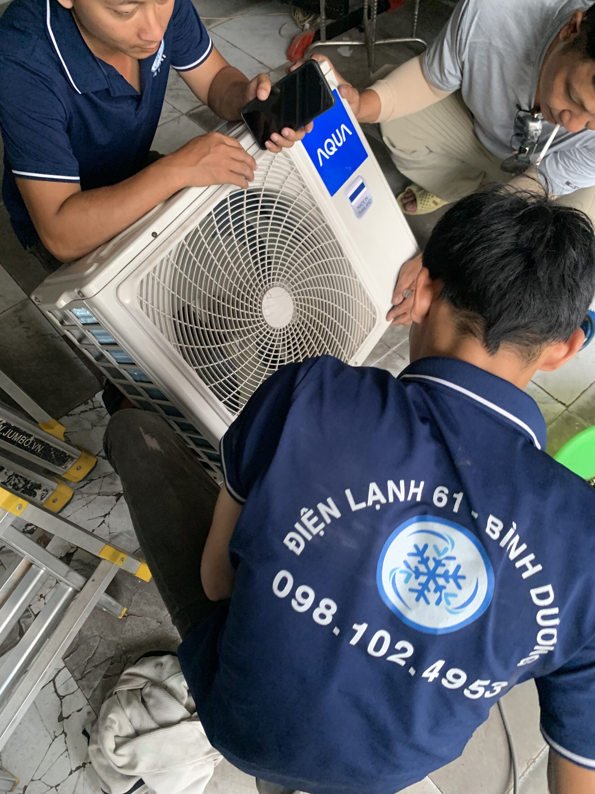 Thợ sửa máy lạnh đang thay tụ quạt dàn nóng